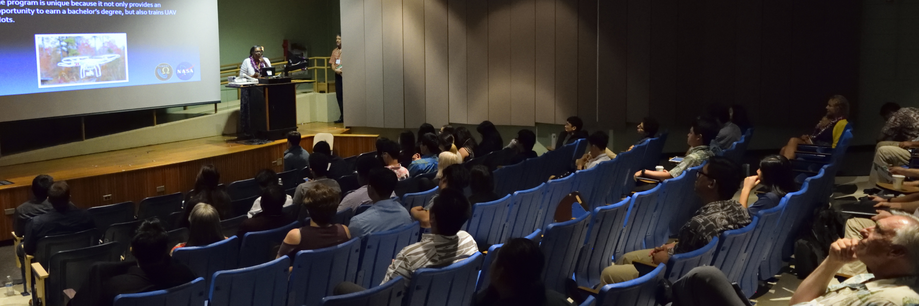 A Female NASA Administrator On Stage Addressing Students.