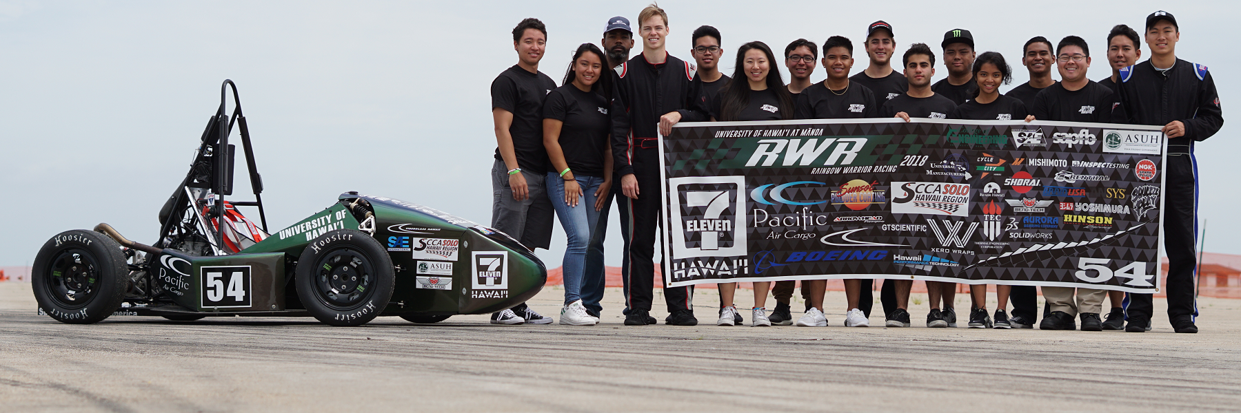 SAE Team With Car And Sponsors Banner.