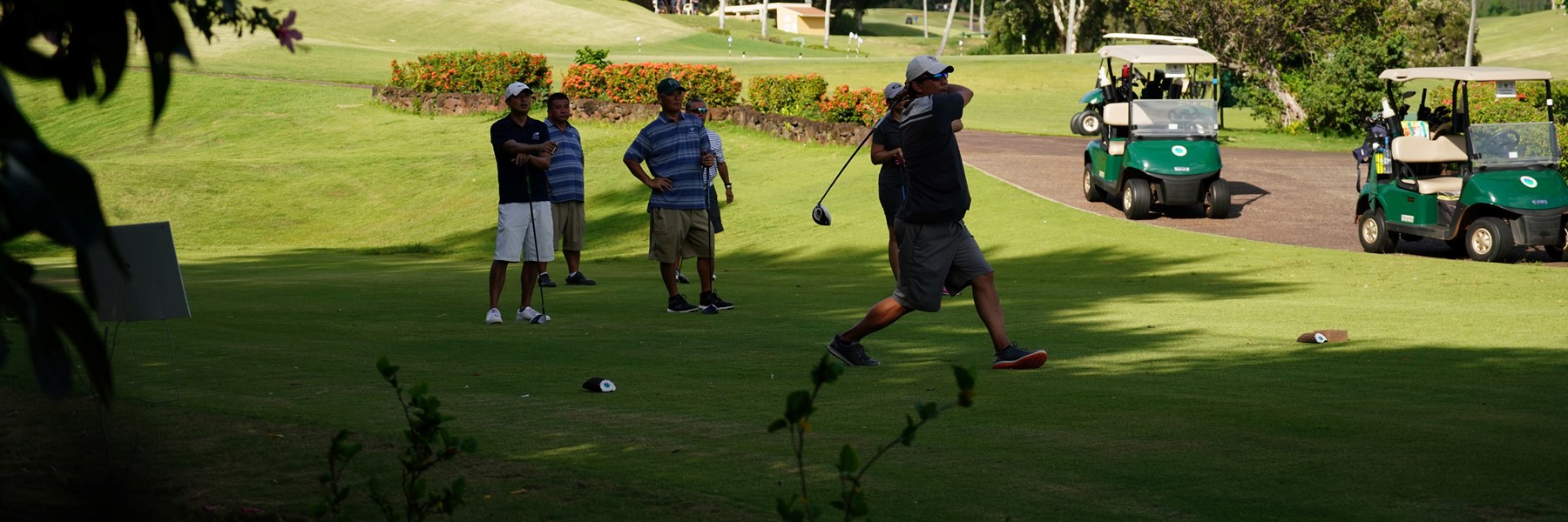 Golfer Taking A Mean Crack At The Ball While Others Stand Around Watching.