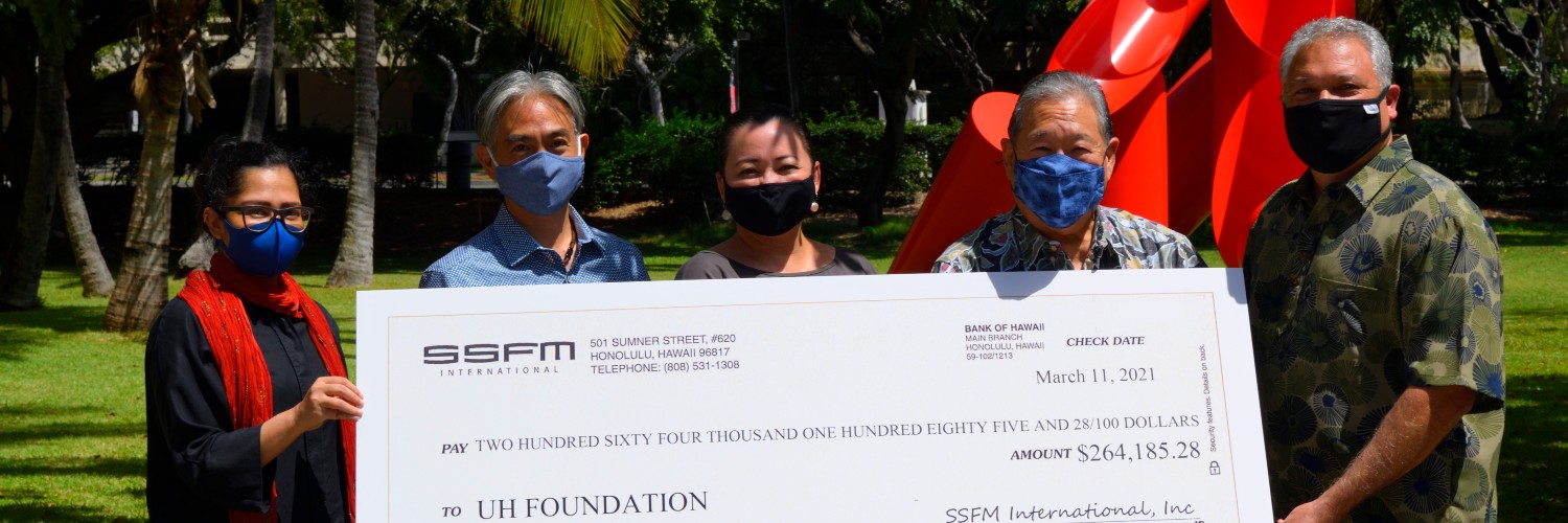 Group Of People Holding A BIG Check In Front Of The Gate Of Hope Sculpture